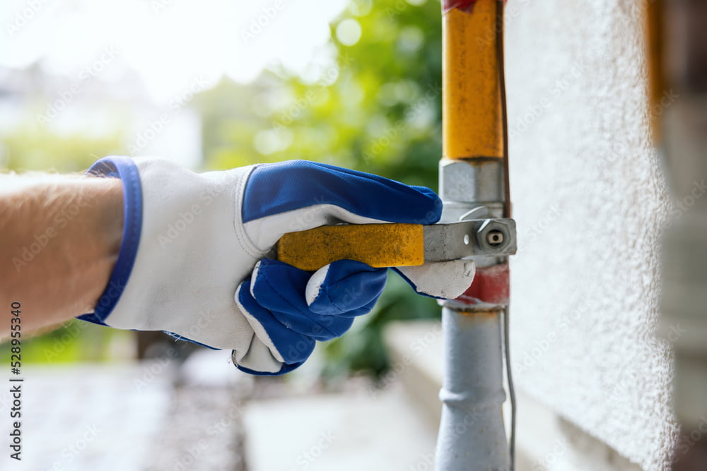 hand closes the household gas pipe valve
